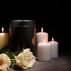 Urna cineraria con candele e rose bianche — cremazione certificata Napoli